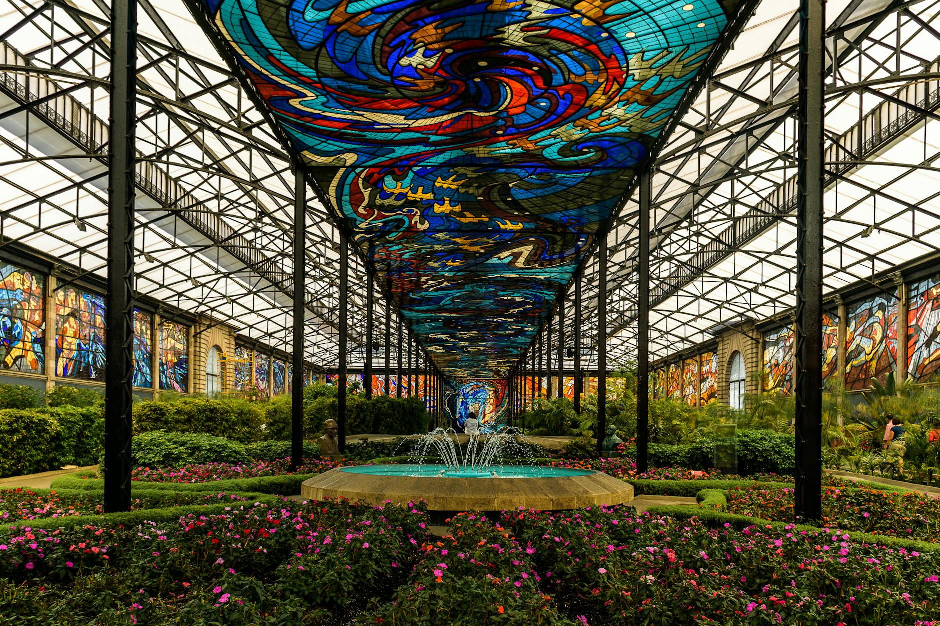 Vibrant stained glass ceiling with fountain in Cosmovitral, Toluca.