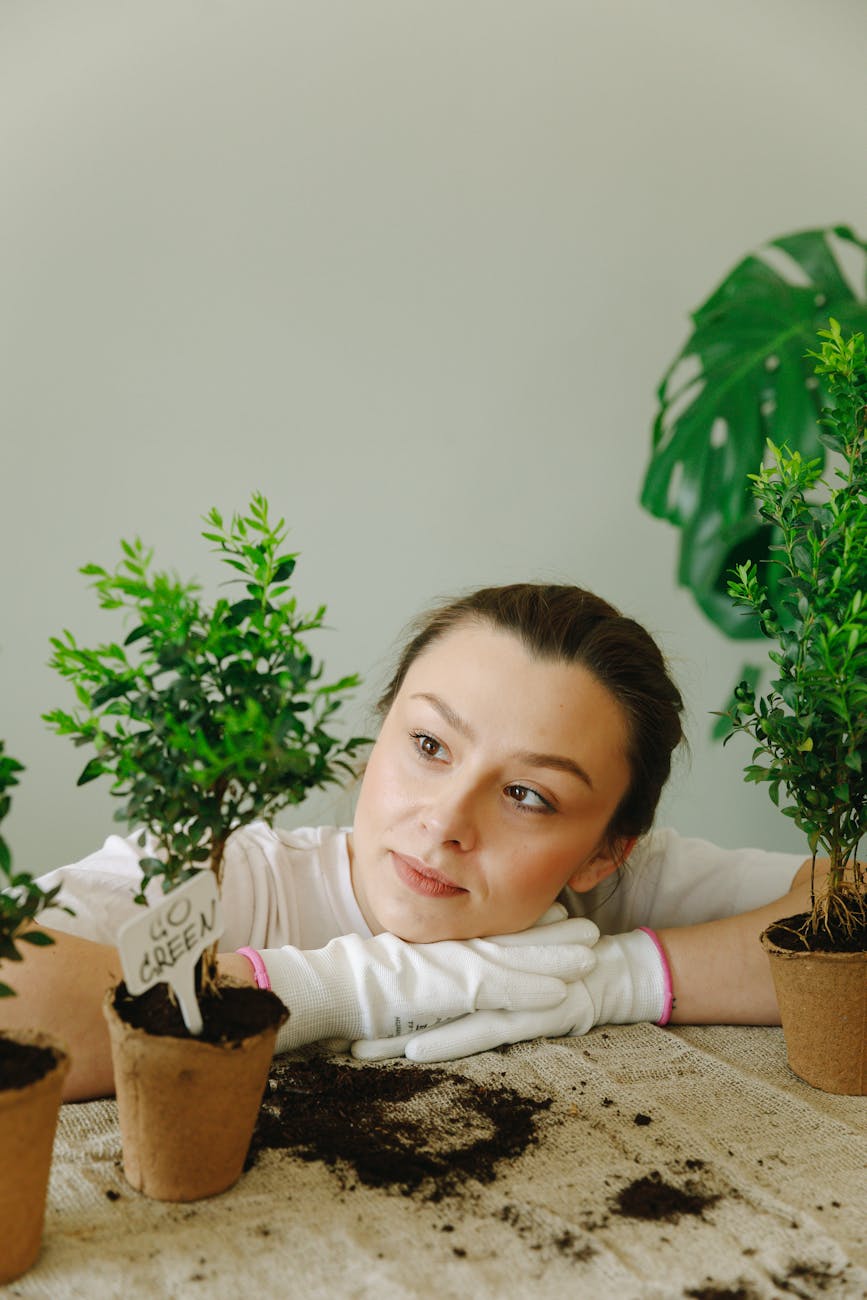 Young woman gardening indoors with eco-friendly practices and leafy plants.