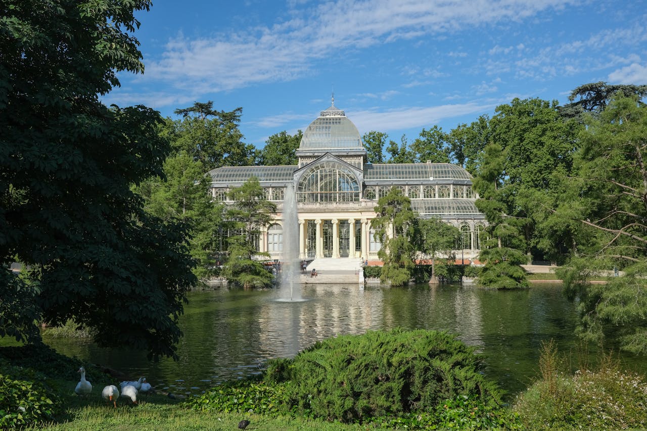 services-03 Beautiful summer view of Palacio de Cristal with lush surroundings and tranquil pond.