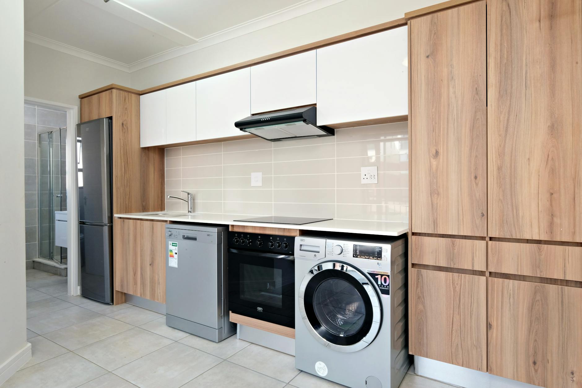 A sleek modern kitchen design featuring wooden cabinetry and integrated appliances.